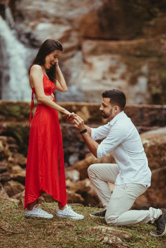 Capture of a heartfelt marriage proposal at a stunning outdoor waterfall.