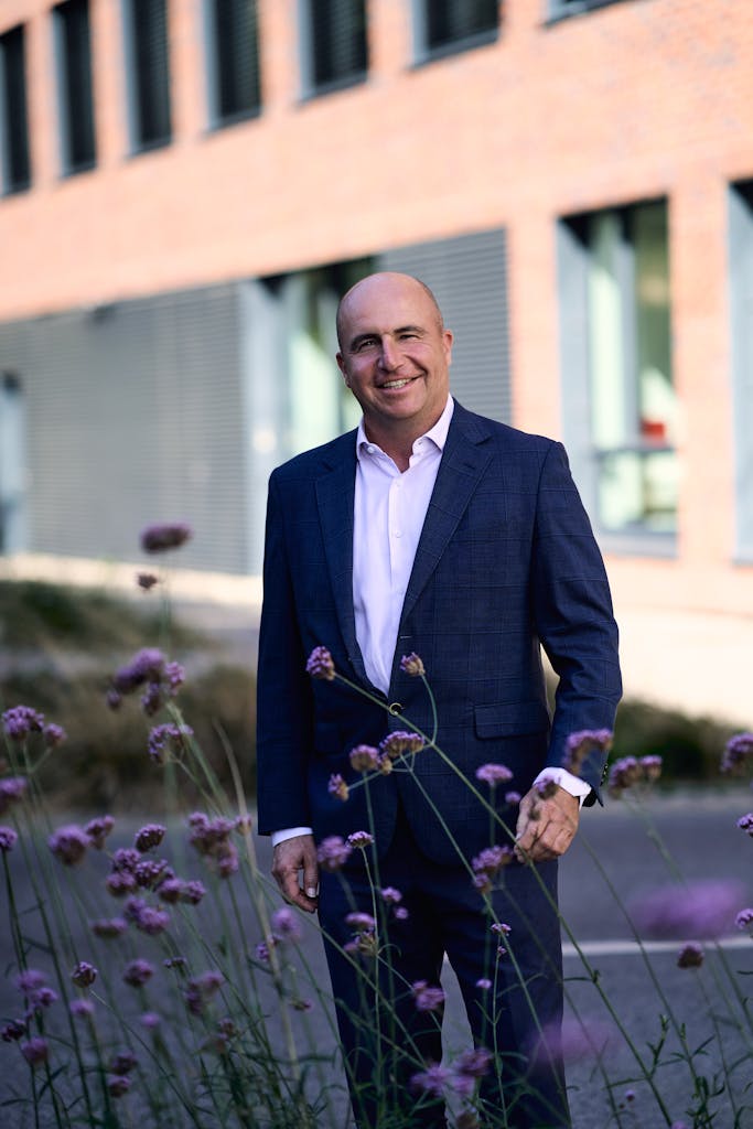 Confident businessman in formal attire standing outside an office building in Bratislava.