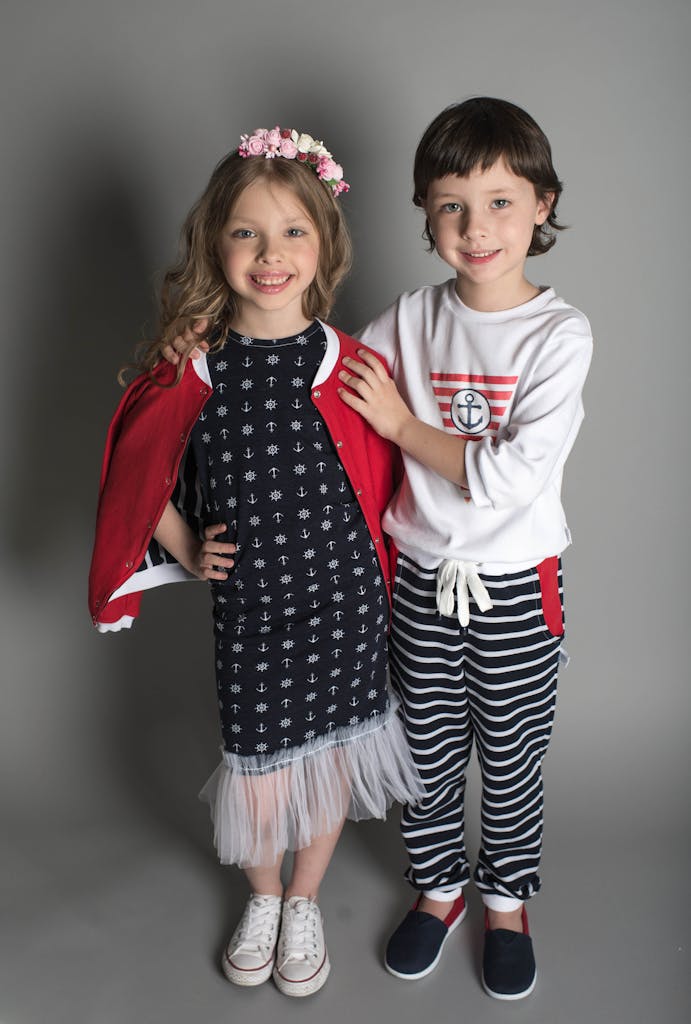 Cute children posing in stylish nautical-themed outfits with happy expressions.