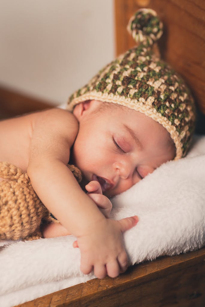 Peaceful baby sleeping on a soft bed, wearing a knitted hat. Heartwarming and cute.