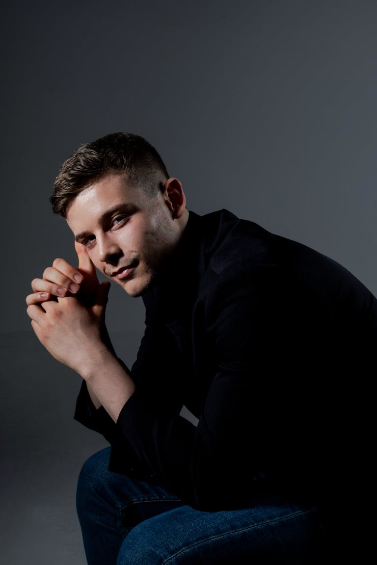 Portrait of a young man wearing dark clothes, thoughtfully posed.