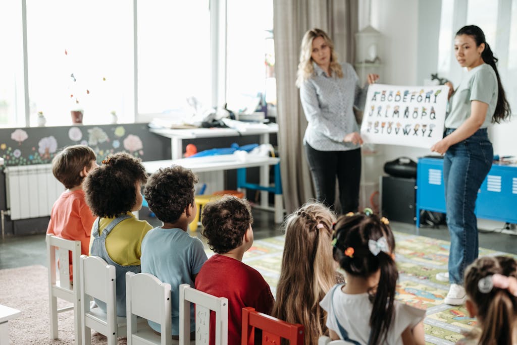 Teachers engage children in learning alphabet during a kindergarten class.